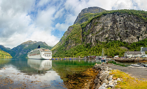 在Geiranger村与Fjor一起停泊在Geiranger村港口的游轮图片