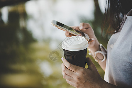 年轻女性持有可支配咖啡杯和短信短讯t图片