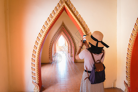 旅游妇女在寺庙观光时玩得开心 亚洲妇女在宗教崇拜中用艺术古建筑拍摄佛像时放松和享受 旅游探索建筑学访问照片精神帽子游客建筑旅行拍图片