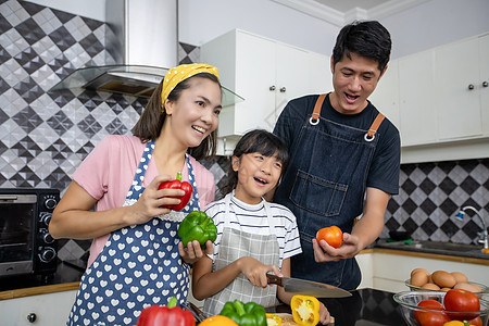 快乐的家庭有爸爸 妈妈和她们的女儿 在厨房一起烹饪 笑声面包桌子微笑羊角女性男人父母孩子食物男性图片
