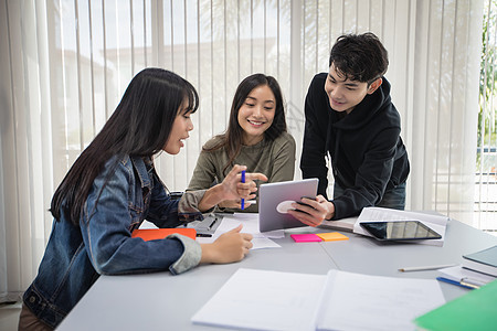 亚洲组学生团体 微笑和阅读书及使用笔记本桌子校园女孩男性朋友幸福考试写作女性学校图片