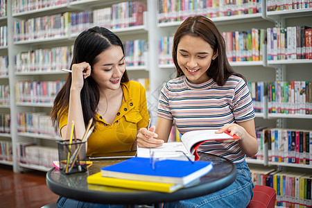 亚洲学生小组微笑并阅读书籍并使用笔记本来帮助分享工作和项目中的想法 还有考前复习这本书女士团体家庭作业朋友学习写作青年青少年大学图片