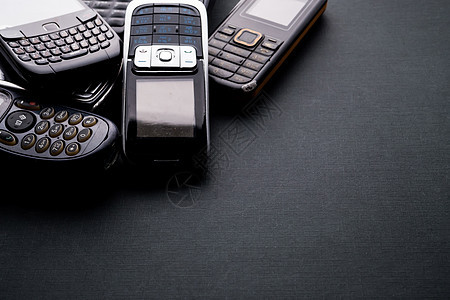 黑色背景中的旧手机和过时手机纽扣收藏屏幕电子电气金属垃圾技术电话回收图片