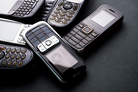 黑色背景中的旧手机和过时手机收藏展示电子细胞垃圾回收讲话数字电话工具图片
