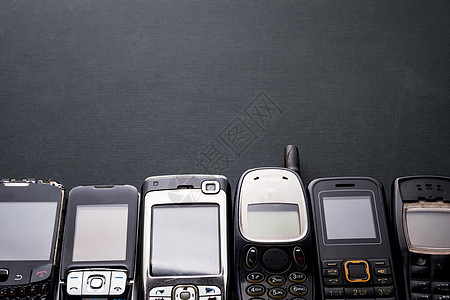 黑色背景中的旧手机和过时手机数字展示金属电话收藏工具屏幕回收技术电子图片