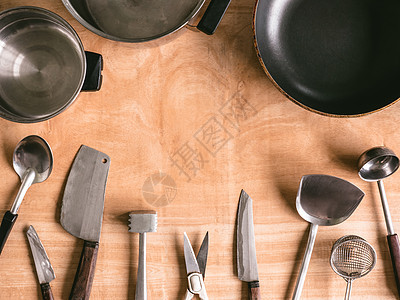 木桌背景的厨房用具肉锤厨师桌子美食工具金属切菜板烹饪餐具平底锅图片