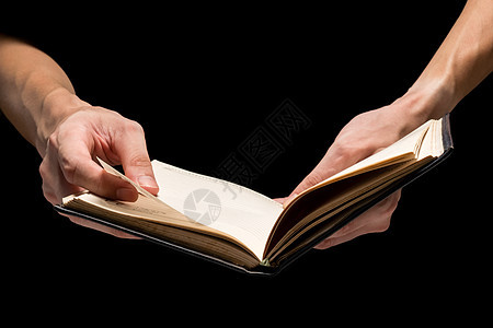 男性手拿着一张黑背景的空白笔记本手指电子日记表格笔记文学文档阅读教科书图片