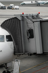 机场上的飞机连接到门套 飞机和套筒 机场门口供乘客登机空气方法航班技术商业天空假期建筑客机引擎背景图片