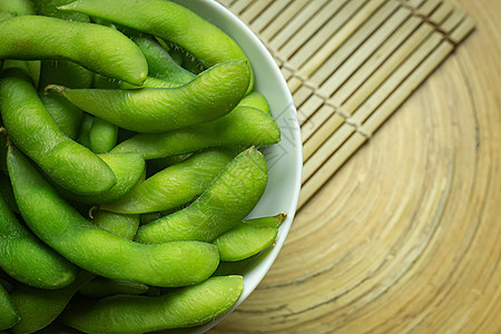 Edamame在白碗中展示食物内容的顶端视图图像蔬菜桌子大豆营养毛豆饮食绿色美食小吃豆类图片