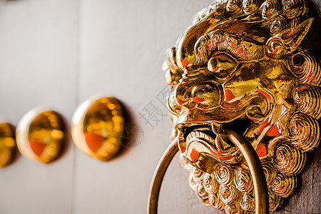 Wooden门的金金属狮子门敲钟者金属门把手金色寺庙建筑学材质文化木材金子建筑图片