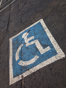 铺在沥青上的残疾人停车标志蓝色运输障碍路面残障人士公园街道轮椅图片