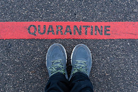 穿着运动鞋的男子站在红色线条旁边 有文字QUARANTINE图片
