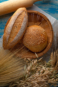 黑麦面粉木制桌上的新鲜烤熟传统面包厨房桌子小麦乡村食物烹饪包子谷物脆皮面粉背景