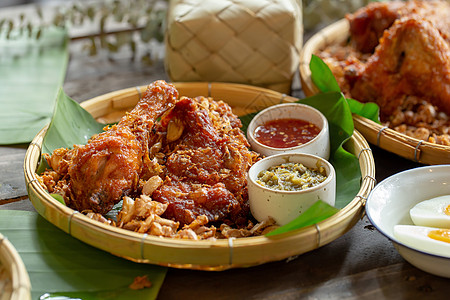 木桌边的大蒜炸鸡烹饪翅膀午餐红色熏制油炸餐厅食物盘子煎锅图片