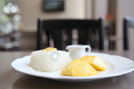 与芒果在木材背景上的粘黏性稻米牛奶甜点水果叶子热带坚果食物美食饮食午餐图片