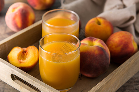 木制桌上的玻璃中天然桃子汁饮食食物水果营养木头早餐果汁杯子液体图片
