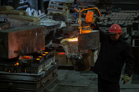工人们用熔化钢板和起重机在填充形式之前移动冶金吊轴图片