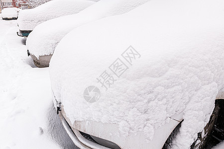 白雪皑皑的汽车在白天停车时经常遭受暴风雪-广角图片图片