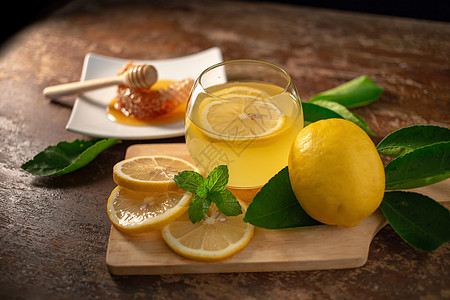 蜂蜜柠檬水含蜜的柠檬汁和木制桌上的蜂蜜 柠檬和红树叶热带黄色薄荷糖浆蜂窝玻璃草本植物派对果汁细胞背景