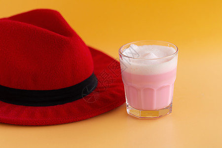 红帽子和草莓奶昔 从黄色背面的玻璃上图片