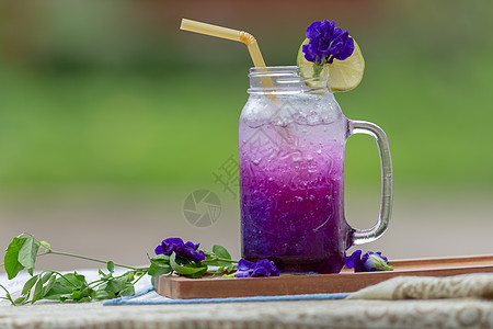 鲜紫蝴蝶梨或蓝豌豆花和柠檬汁食物紫色柠檬木头玻璃茶点果汁桌子植物植物群图片