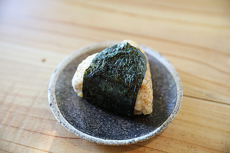Onigigiri用木本底的当地日本食品午餐三角形饭团海苔酱油食物文化盘子棕色海藻图片