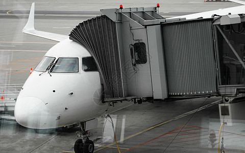机场上的飞机连接到门套 飞机和套筒 机场门口供乘客登机技术航班方法建筑航空飞机场涡轮人行道假期喷射背景图片