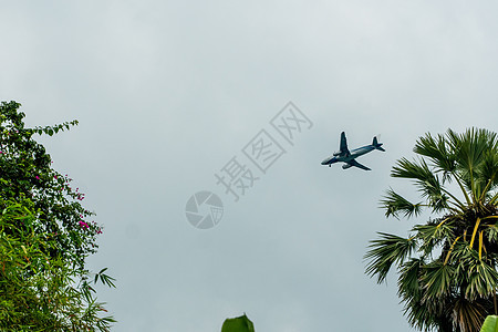 飞机在云层中飞行 准备降落在一个热带岛屿上空气翅膀涡轮航空奢华天际阳光货物安全喷气图片