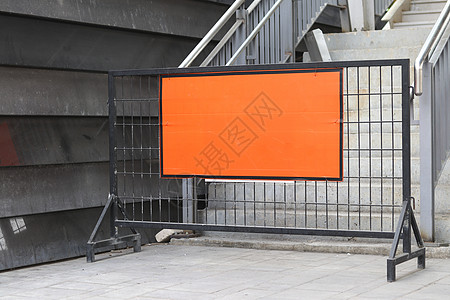 金属广告牌在楼梯对面贴有橙色标签的钢铁屏障背景