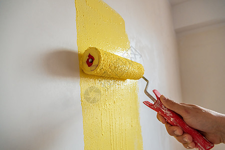 工人把墙涂成黄色墙纸刷子滚筒男人维修画家装修房子装潢师装饰图片