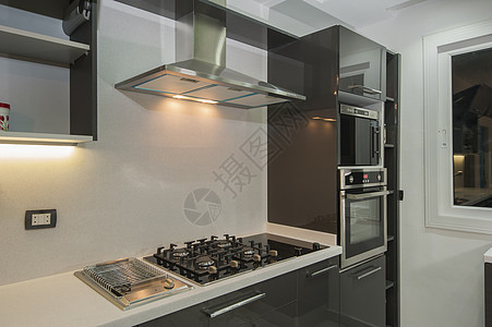 在豪华公寓的现代厨房风格烤箱炉灶家具排气扇架子器具电烤箱柜台装饰图片