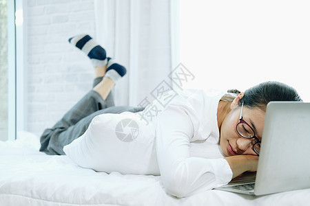 床上电脑睡着躺在床上躺着的女士 在电脑上头部倒下背景