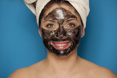 年轻美女脸上戴黑面罩 脸上披着黑面具蓝色毛巾产品温泉女孩护理木炭化妆品女士卫生图片