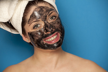 年轻美女脸上戴黑面罩 脸上披着黑面具产品化妆品女孩保健木炭皮肤女士卫生温泉护理图片