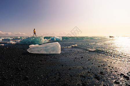 站在冰岛钻石海滩冰山的旅游者们地标旅游场景吸引力阳光活动男生游客旅行水晶图片