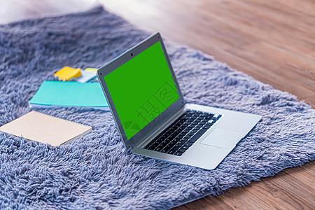 灰地毯上绿色屏幕的顶顶膝盖电脑木头绿屏桌子工作照片记事本商业笔记本职场办公室背景图片