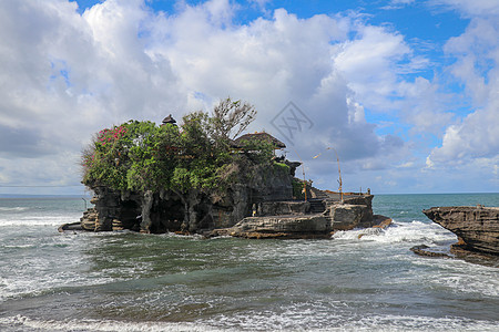 海浪在悬崖上破碎 悬崖顶部是海神庙的印度教寺庙 建在印度尼西亚巴厘岛海岸外海中岩石上的寺庙 悬崖顶上茂密的热带植被风暴滚动天空海背景图片
