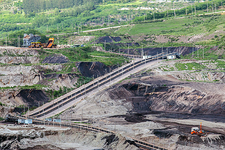 矿坑的一部分 大型采矿卡车在工作挖掘机地球搬运工车辆黄色矿物煤炭工业矿石褐煤图片