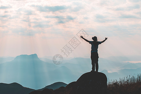 在山峰上穿梭银轮 成功的概念是成功的商业爬坡岩石领导顶峰蓝色男人游客日落天空图片