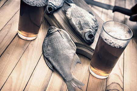 两杯啤酒和干鱼清新剂酒吧盐渍夫妻美味木头眼镜泡沫啤酒杯食物图片