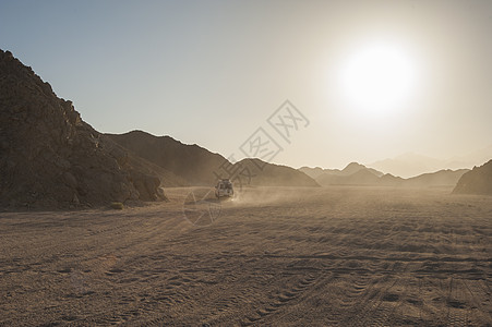穿越干旱沙漠地貌的越野公路车辆图片