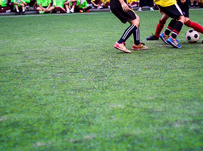 足球运动员在小学体育比赛中竞相参赛闲暇娱乐孩子场地绿色跑步乐趣团队活动训练背景图片