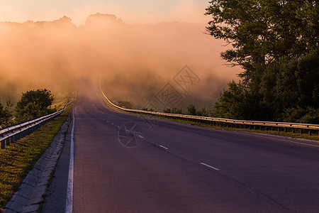 清晨浓密的雾雾 在河附近的夏季高速公路上用防守铁轨织成栏杆旅行危险日落森林安全阴霾金属驾驶沥青图片