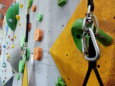 争先恐后在室内的人造墙上攀爬 攀岩设备 CrossFit 绳索和 用于在陡峭的岩石 极限运动和抱石概念上向上移动安全公园训练冒险操场爱好背景