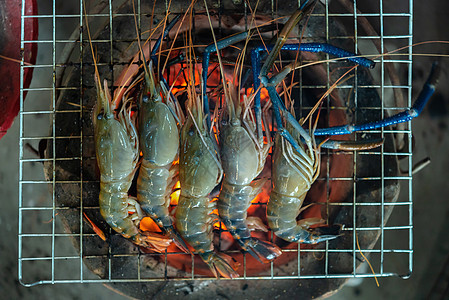 市场上的灰虾干淡水大虾烹饪火焰午餐炙烤木炭派对饮食食物贝类街道图片