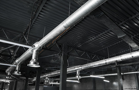 大型建筑物天花板上的通风系统 新建筑天花板上悬挂着银色绝缘材料的通风管金属管子工厂暖通护发素冷气机技术建造管道发泄图片