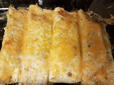 以玻璃锅中奶酪加芝士的enchiladas食物火炉平底锅玻璃午餐图片