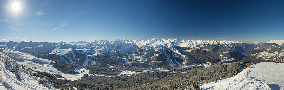 高山山脉下雪覆盖山谷的风景全景蓝色天空针叶树树木针叶爬坡道山脉森林天气远景图片