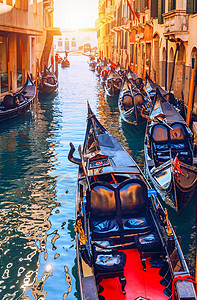 运河和意大利威尼斯的贡多拉斯 建筑和地标渠道缆车天际广场旅行游客运输历史性景观日落图片