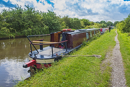 英国运河上的窄船在农村的一条小河上爬坡旅行衬套英语窗户运输人行道反射水路自行车图片
